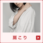 肩こりに悩む女性が肩に手を当てている写真